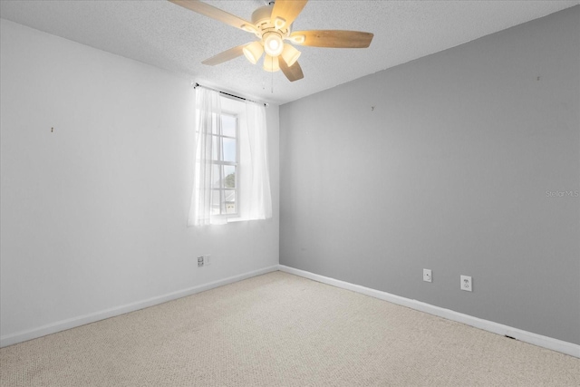 unfurnished room with light carpet, a ceiling fan, baseboards, and a textured ceiling