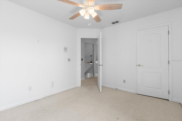 unfurnished bedroom featuring light carpet, baseboards, visible vents, and ceiling fan