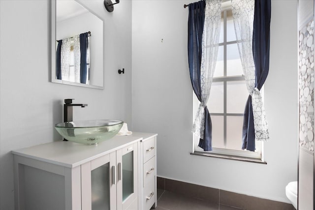 bathroom featuring tile patterned flooring, plenty of natural light, vanity, and toilet