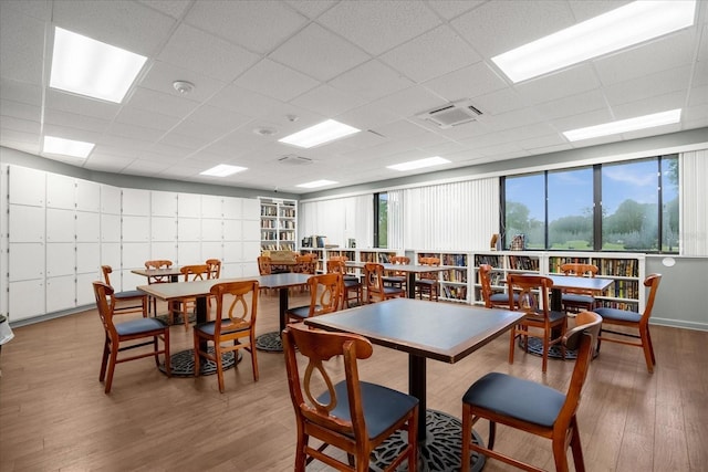 recreation room featuring a paneled ceiling and hardwood / wood-style flooring