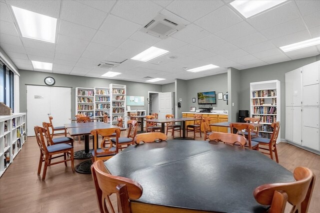 recreation room featuring a paneled ceiling and light hardwood / wood-style floors