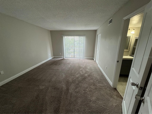 carpeted empty room with a textured ceiling