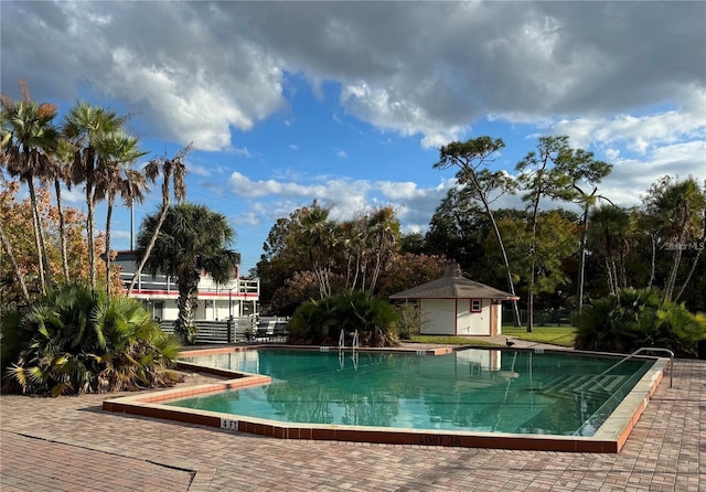 view of pool featuring an outbuilding and a patio