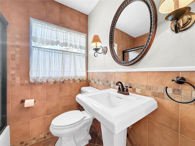 bathroom with sink, tile walls, toilet, and tile floors