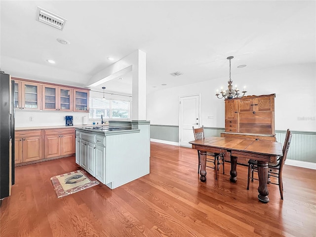 kitchen with an inviting chandelier, hanging light fixtures, a center island, and hardwood / wood-style flooring