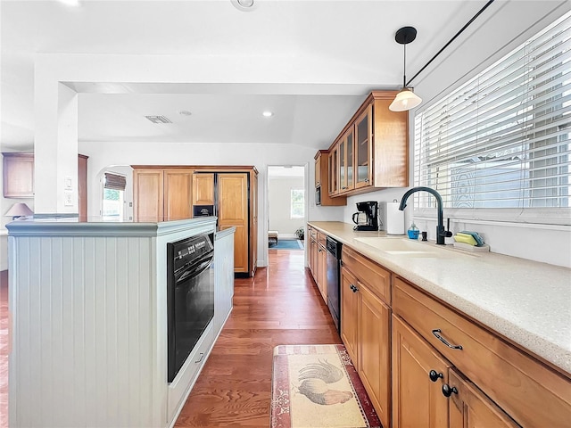 kitchen with decorative light fixtures, hardwood / wood-style floors, a wealth of natural light, and oven