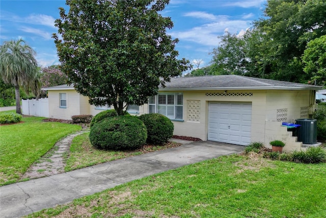 view of front of home featuring a front yard, a garage, and central AC