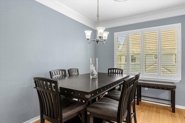 dining space featuring a notable chandelier, wood-type flooring, ornamental molding, and a wealth of natural light