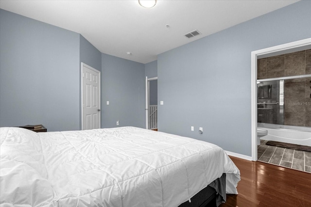 bedroom with hardwood / wood-style flooring and connected bathroom