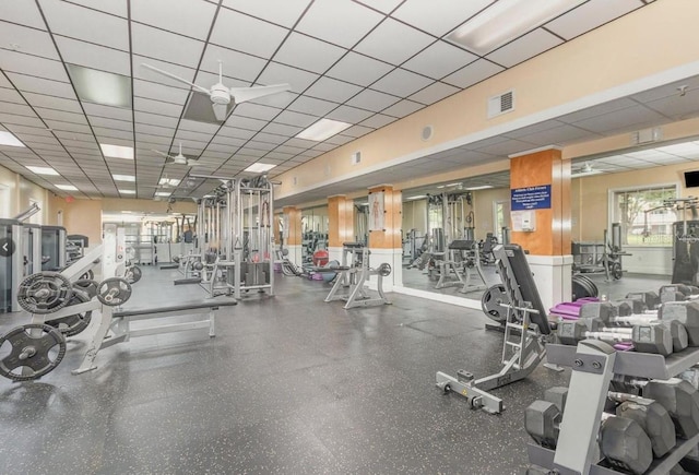 workout area featuring ceiling fan and a drop ceiling