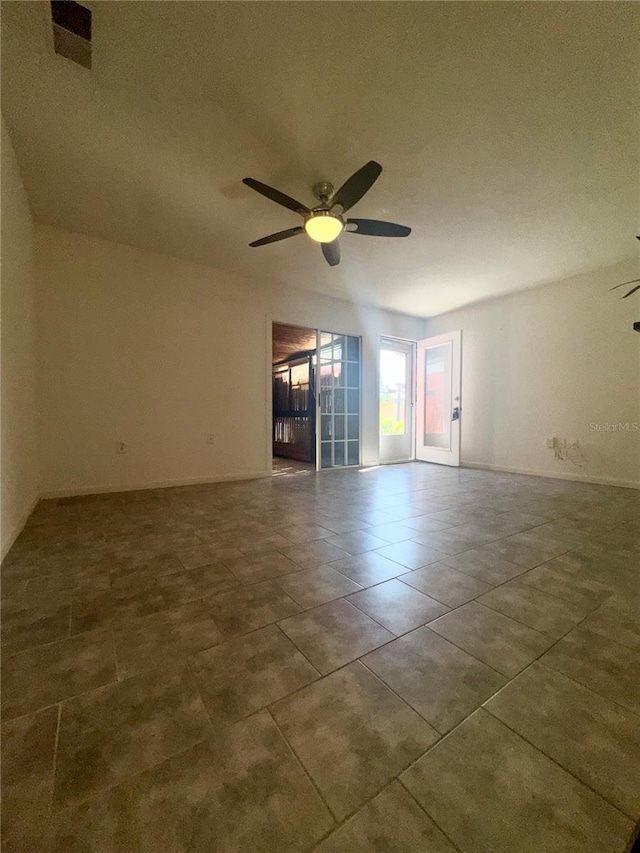 tiled empty room featuring ceiling fan