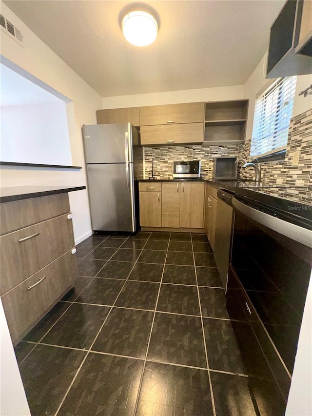 kitchen featuring stainless steel appliances, sink, light brown cabinetry, and backsplash