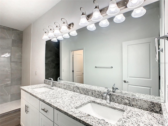 bathroom featuring hardwood / wood-style flooring, vanity, and tiled shower