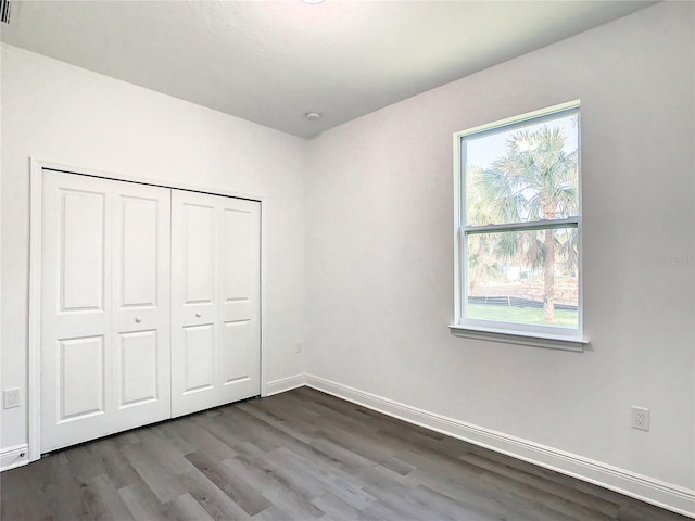 unfurnished bedroom with hardwood / wood-style floors and a closet