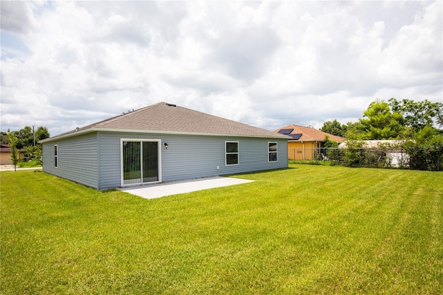 rear view of property featuring a lawn and a patio area