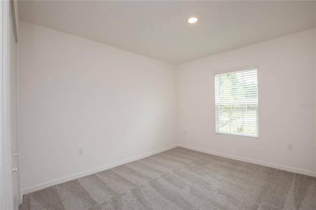 unfurnished room featuring light carpet