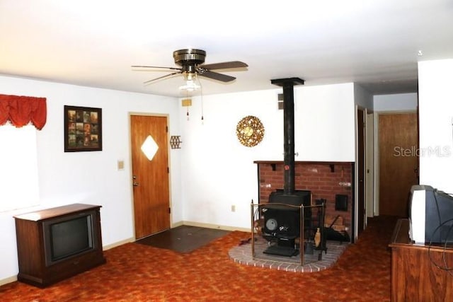 living room with ceiling fan and a wood stove