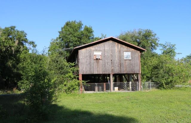 back of house featuring a yard and an outbuilding