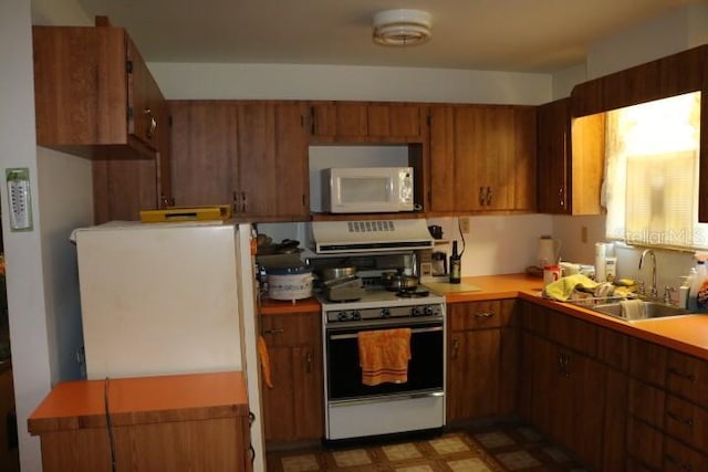 kitchen featuring white appliances and sink