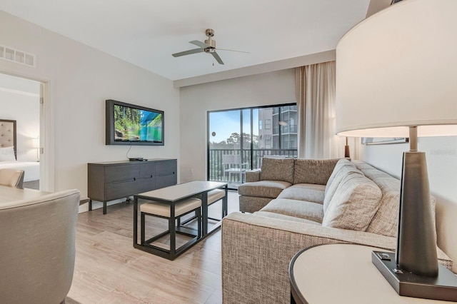 living room featuring light hardwood / wood-style floors and ceiling fan