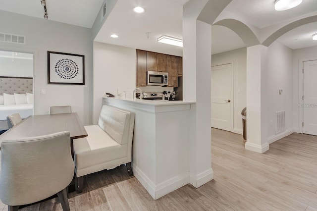 interior space featuring sink, light hardwood / wood-style flooring, and stove