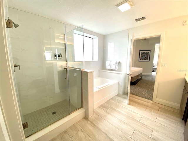 bathroom featuring tile floors, shower with separate bathtub, a textured ceiling, and vanity