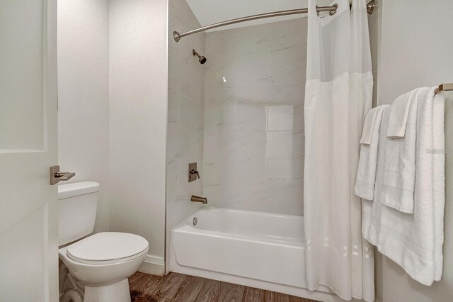 bathroom with shower / bath combo, hardwood / wood-style flooring, and toilet