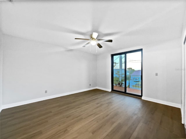 empty room with ceiling fan, dark wood finished floors, and baseboards