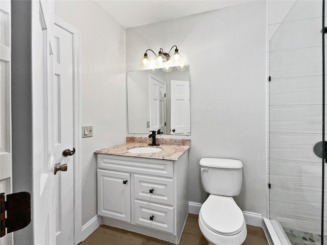 full bath featuring a stall shower, baseboards, vanity, and toilet