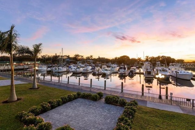 surrounding community with a water view, a yard, and a boat dock