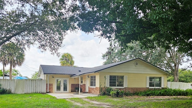 back of house featuring a yard and french doors