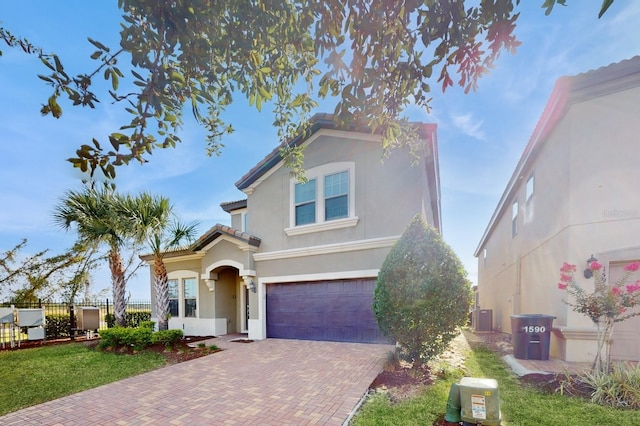 mediterranean / spanish-style home with a garage and central AC