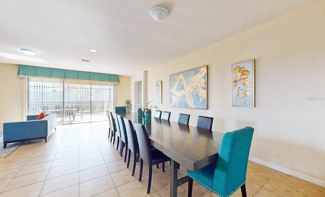 tiled dining space featuring a textured ceiling