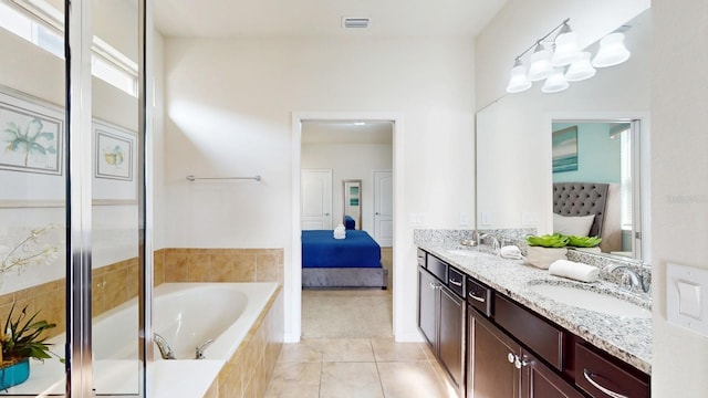 bathroom featuring tiled bath, double sink vanity, and tile floors