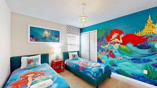 bedroom featuring a chandelier, carpet flooring, a closet, and a textured ceiling