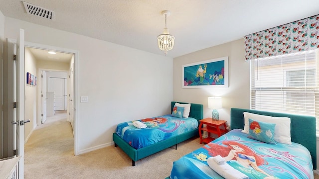 carpeted bedroom with an inviting chandelier