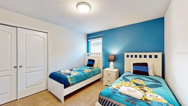 bedroom featuring light colored carpet, a closet, and a textured ceiling