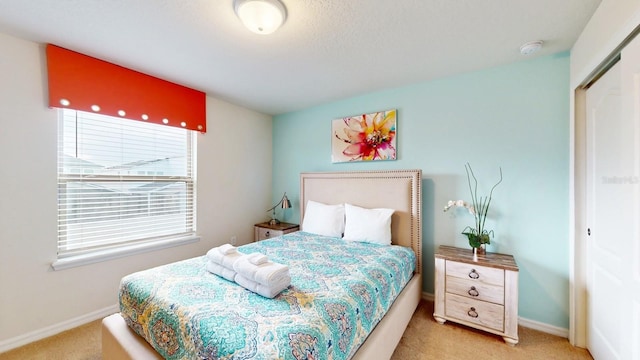 bedroom featuring multiple windows, a closet, and light colored carpet