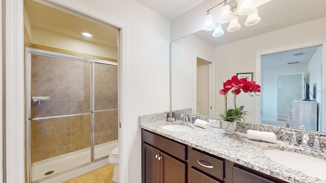 bathroom with double sink, walk in shower, tile floors, toilet, and large vanity