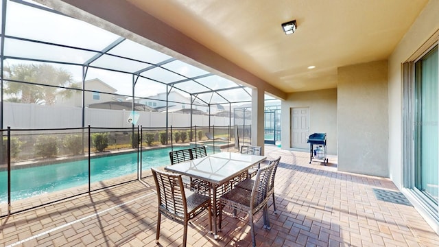 view of pool with glass enclosure, a patio area, and grilling area