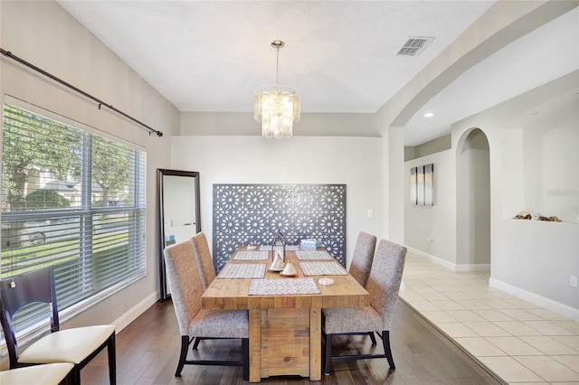 dining space featuring light wood-type flooring and an inviting chandelier