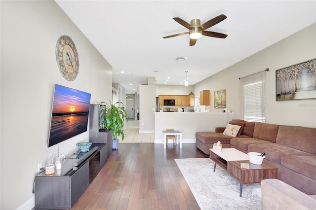 living room featuring ceiling fan and light hardwood / wood-style floors