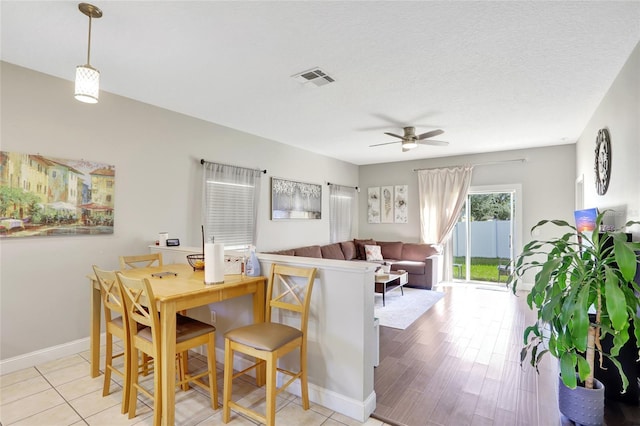 dining space featuring ceiling fan, light hardwood / wood-style floors, and a textured ceiling