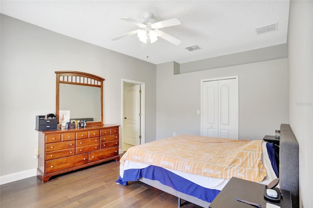 bedroom featuring ceiling fan, wood-type flooring, and a closet