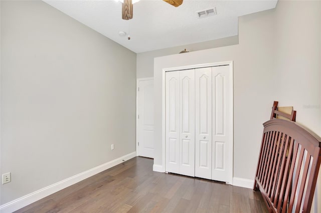 bedroom featuring ceiling fan, a closet, and wood-type flooring