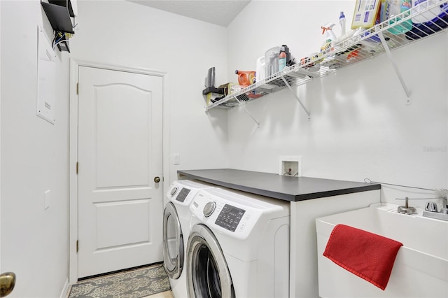 laundry area with separate washer and dryer and sink