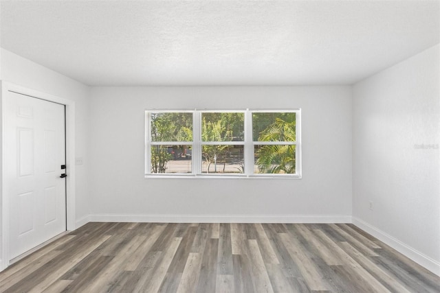 empty room with hardwood / wood-style floors and a textured ceiling