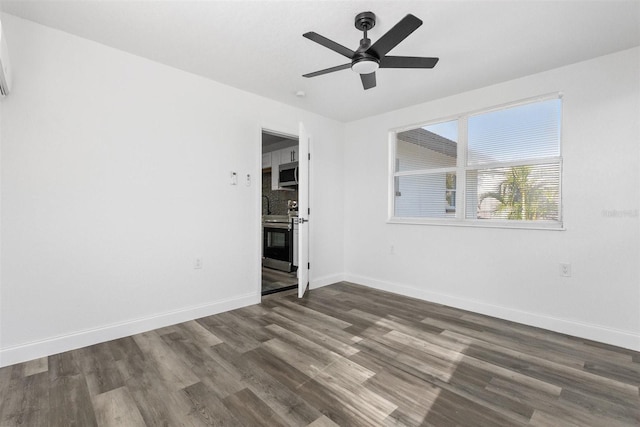 empty room with ceiling fan and dark hardwood / wood-style floors