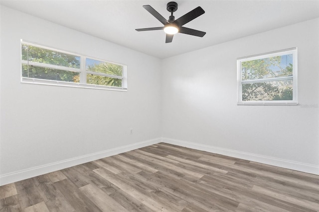 empty room with ceiling fan, a healthy amount of sunlight, and light hardwood / wood-style flooring