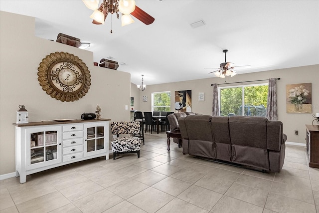 living room with ceiling fan with notable chandelier and light tile patterned floors